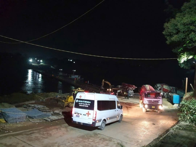 Xe cấp cứu của Trung tâm y tế huyện Thanh Sơn dừng trước cầu phao Phong Châu chuẩn bị đổ bê tông, tối 6/4. Ảnh: Văn Tú