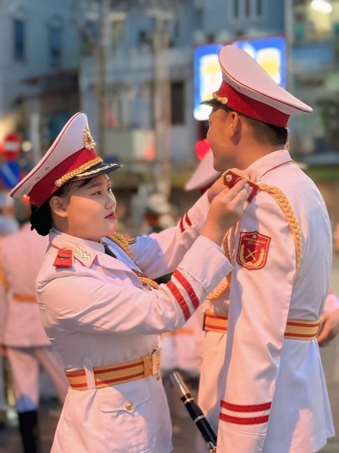 Chiến sĩ Nguyễn Thị Phương Thanh chỉnh lại trang quân trang cho chồng, anh Dương Thanh Bình, 30 tuổi, công tác tại Đoàn Nghi lễ Quân đội, chiều tối 21/8 trên phố Ngọc Hà.