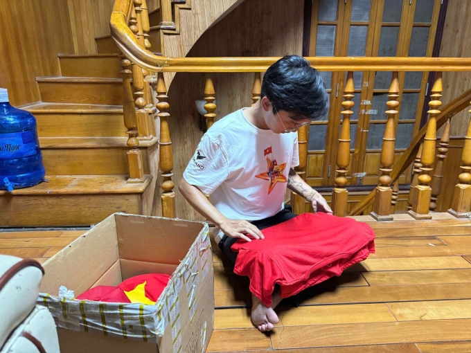 Hoàng Dũng gấp áo in hình cờ Tổ Quốc, chuẩn bị đóng gói gửi tặng học sinh trường Phổ thông dân tộc nội trú THPT Hà Giang, tỉnh Tuyên Quang, chiều 3/9.