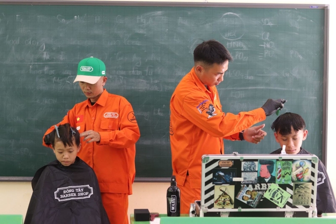 Đại diện Đông Tây Barbershop cắt tóc miễn phí cho các em học sinh tại trường, ngày 15/5/2025. Ảnh: Quỳnh Anh