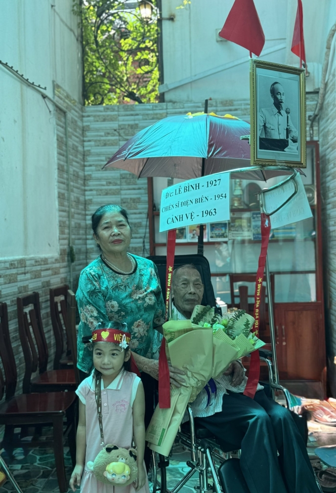 Ông Bình chụp ảnh lưu niệm cùng con cháu trên chiếc xe lăn được chuẩn bị sẵn tham gia diễu binh, hôm 31/8. Ảnh: Phạm Nga